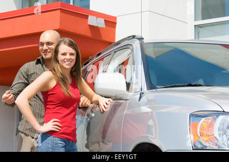 Couple outdoors at car dealership Stock Photo