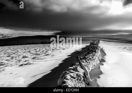 Dramatic rural Yorkshire Dales countryside with a stone wall in the snow in black and white, UK Stock Photo