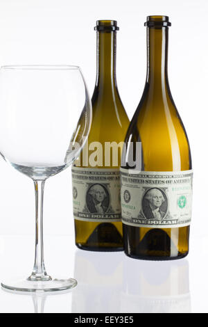 Empty bottles of wine from the label of dollar bill on a glass table Stock Photo