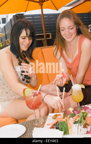 Two women at a sushi restaurant on the patio Stock Photo