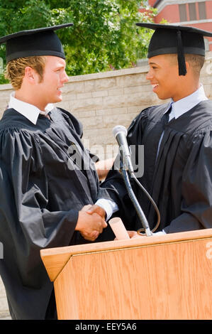 Two friends at podium on graduation day Stock Photo