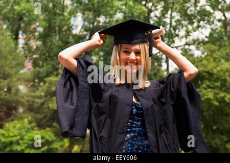 Young woman with diploma on graduation day Stock Photo