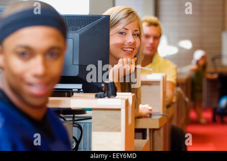 Young adults in a library using computer terminals Stock Photo