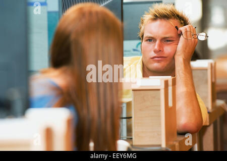 Young adults in a library using computer terminals Stock Photo