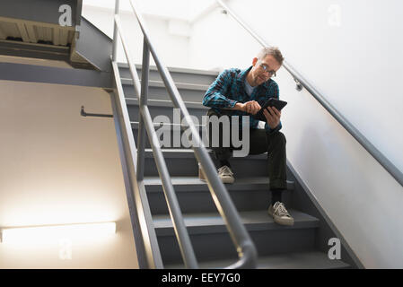 Man sitting on steps using tablet pc Stock Photo
