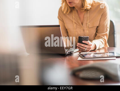 Business woman using laptop and cell phone Stock Photo