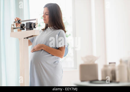 Pregnant woman on scale in doctor's office Stock Photo