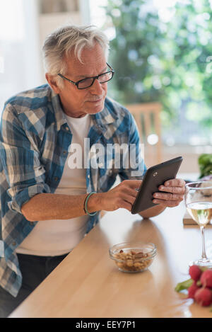 Man in kitchen using tablet Stock Photo
