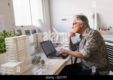 Architect working on laptop in his office Stock Photo