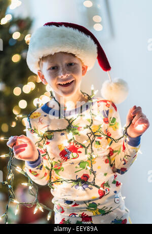 Portrait of boy (6-7) holding christmas lights Stock Photo
