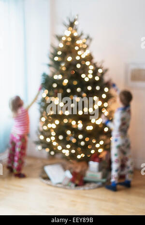 Sister and brother (4-5, 6-7) decorating christmas tree Stock Photo