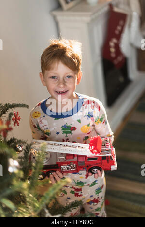 Portrait of boy (6-7) holding toy firetruck Stock Photo