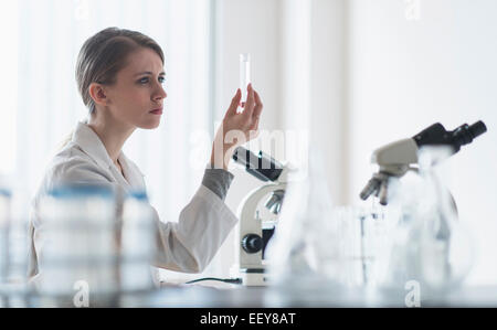 Female lab technician examining liquid in test tube Stock Photo