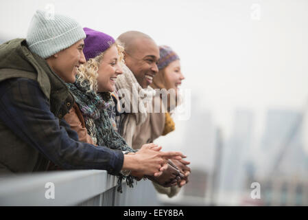 Friends standing on bridge and laughing Stock Photo