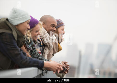 Friends standing on bridge and laughing Stock Photo