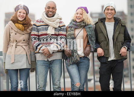 Portrait of happy friends leaning against bridge railing Stock Photo