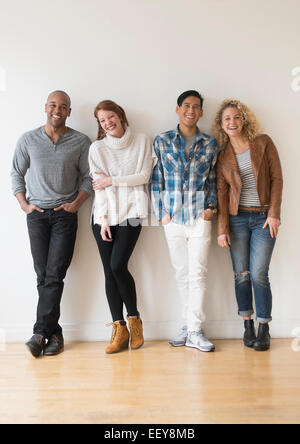 Group of friends standing in front of white wall Stock Photo