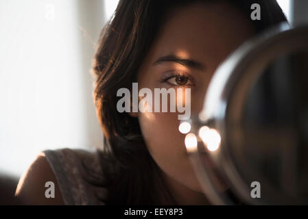 Young woman looking into mirror Stock Photo