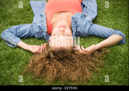 Young woman lying on lawn Stock Photo