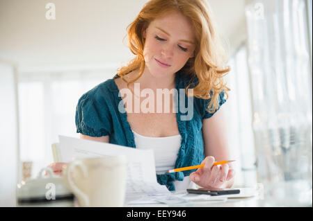 Young woman doing paperwork at home Stock Photo