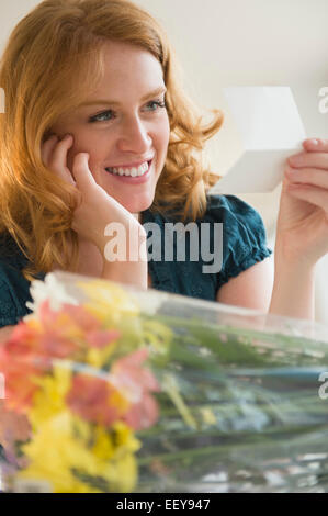 Young woman reading postcard Stock Photo