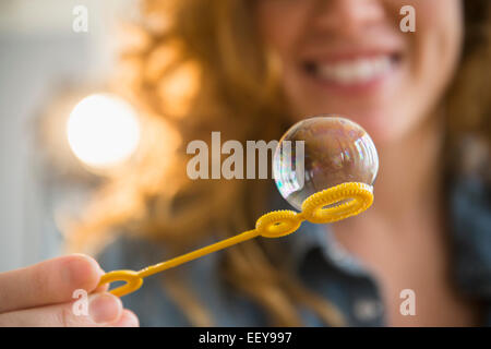 Woman blowing bubbles Stock Photo