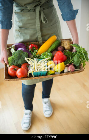 Young woman holding tray with vegetables