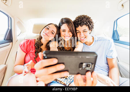 Young people and teenager (14-15) taking selfie in car Stock Photo