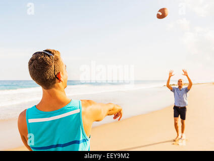 USA, Florida, Jupiter, Young men playing football on beach Stock Photo