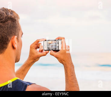 USA, Florida, Jupiter, Young man taking photo of sea Stock Photo