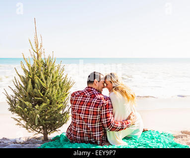 USA, Florida, Jupiter, Loving couple sitting on beach with tree Stock Photo