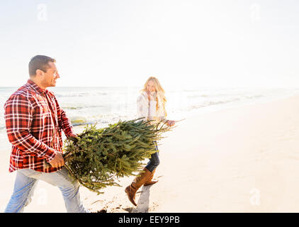 USA, Florida, Jupiter, Loving couple walking on beach with tree