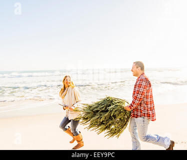 USA, Florida, Jupiter, Loving couple walking on beach with tree