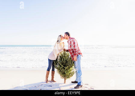 USA, Florida, Jupiter, Loving couple kissing on beach beside tree Stock Photo