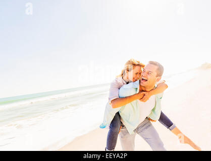 USA, Florida, Jupiter, Man giving woman piggyback ride Stock Photo