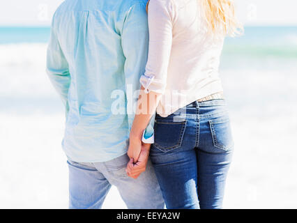 Man and woman holding hands on beach Stock Photo