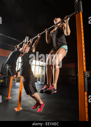 People doing pull-ups at gym Stock Photo