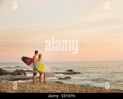 USA, California, Laguna Beach, Mid-adult couple talking on beach at sunset Stock Photo