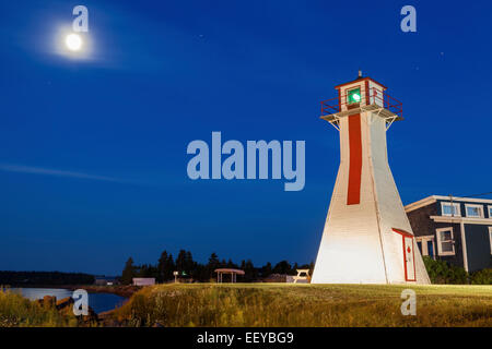 Canada, New Brunswick, Prince Edward Island, Lighthouse on grassy hill under full moon Stock Photo