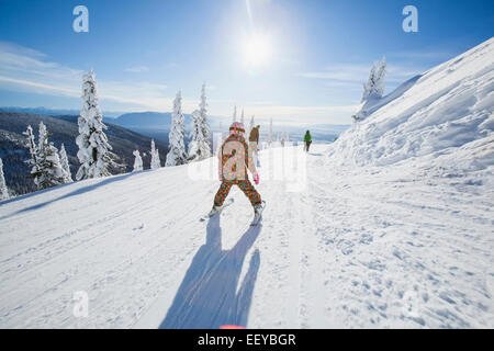 USA, Montana, Whitefish, Girl (8-9) skiing in mountains Stock Photo