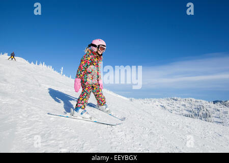 USA, Montana, Whitefish, Girl (8-9) skiing in mountains Stock Photo