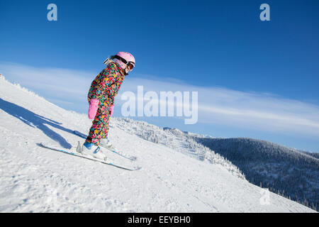 USA, Montana, Whitefish, Girl (8-9) skiing in mountains Stock Photo