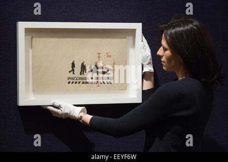 London, UK. 23 January 2015. A Bonhams employee poses with the Banksy picture 'Precision Bombing'. Bonhams auction house previews items from the 'Founded 1793' contemporary art auction taking place on 28 January 2015. The sale includes a collection of 30 Banksy prints owned by the English gallery owner, Steve Lazarides, and a ukulele decorated by Damien Hurst. Photo: Bettina Strenske Stock Photo