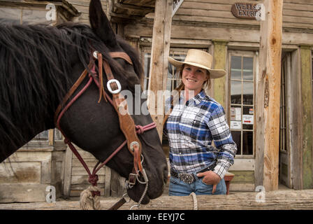 Virginia City Overland Stage employee Mariah Fredrickson waits with her horse Oakley for a stage coach tour to return outside the company’s office in Virginia City, Montana (Photo by Ami Vitale) Stock Photo