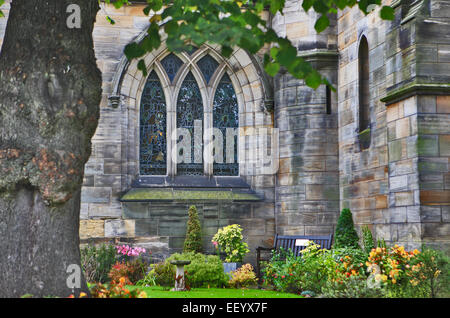 One of the stain glass windows and grounds of The Holy Trinity Church in St Andrews Scotland. Stock Photo