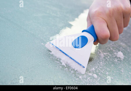 Close Up Of Hand Scraping Ice From Car Windshield With Scraper Stock Photo