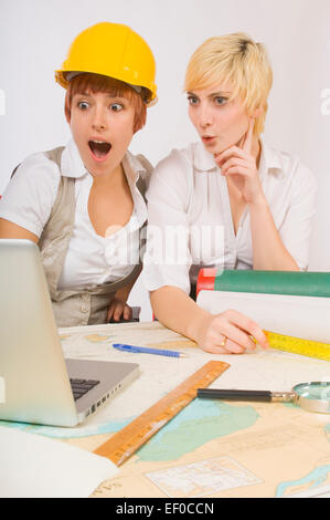 Two surprised women looking at laptop Stock Photo