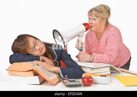 Teacher holding megaphone beside sleeping student Stock Photo