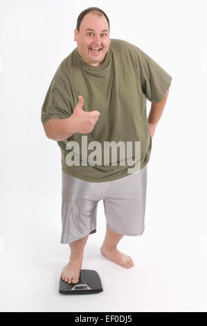 Overweight man standing on a scale Stock Photo