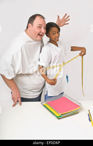 Nurse and patient measuring their midriffs at the same time Stock Photo